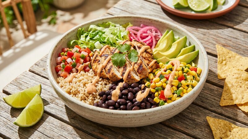 Healthy burrito bowl with grilled chicken, rice, beans and fresh toppings